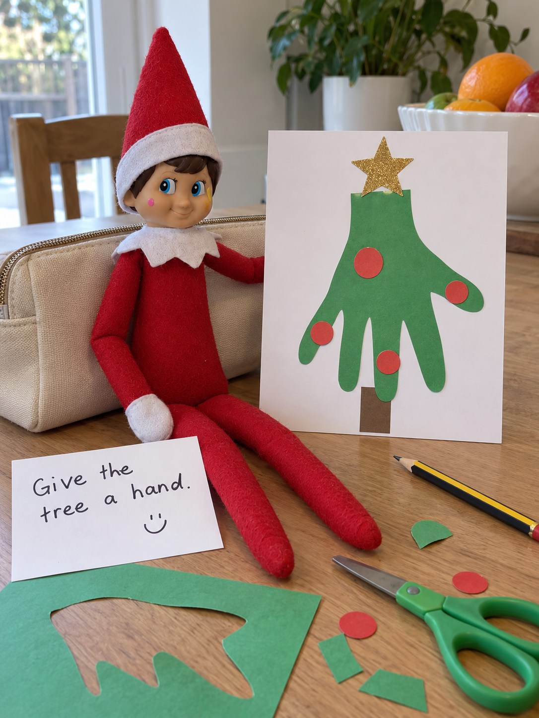 Tom’s elf beside a single five-finger green paper hand decorated as a Christmas tree on white card, with a Give the tree a hand note.