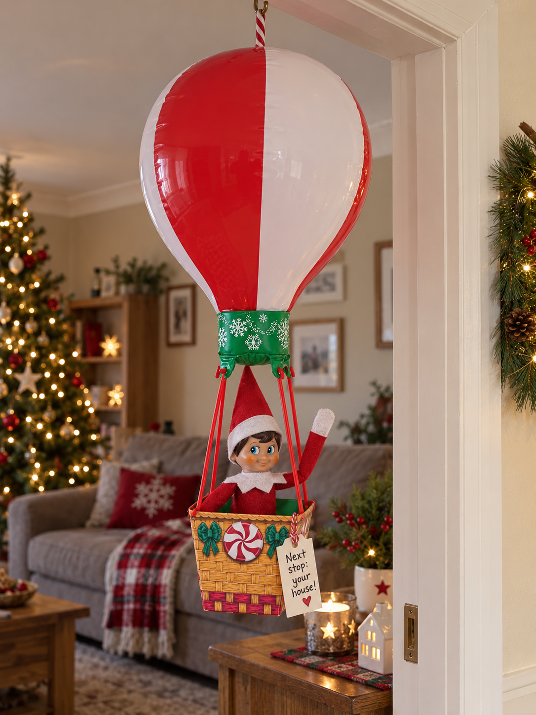 Tom the elf arriving in the basket of a large red and white peppermint balloon