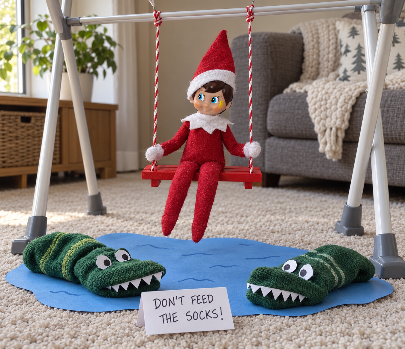 Tom’s elf on a red wooden swing above a blue paper pond with two sock crocodiles