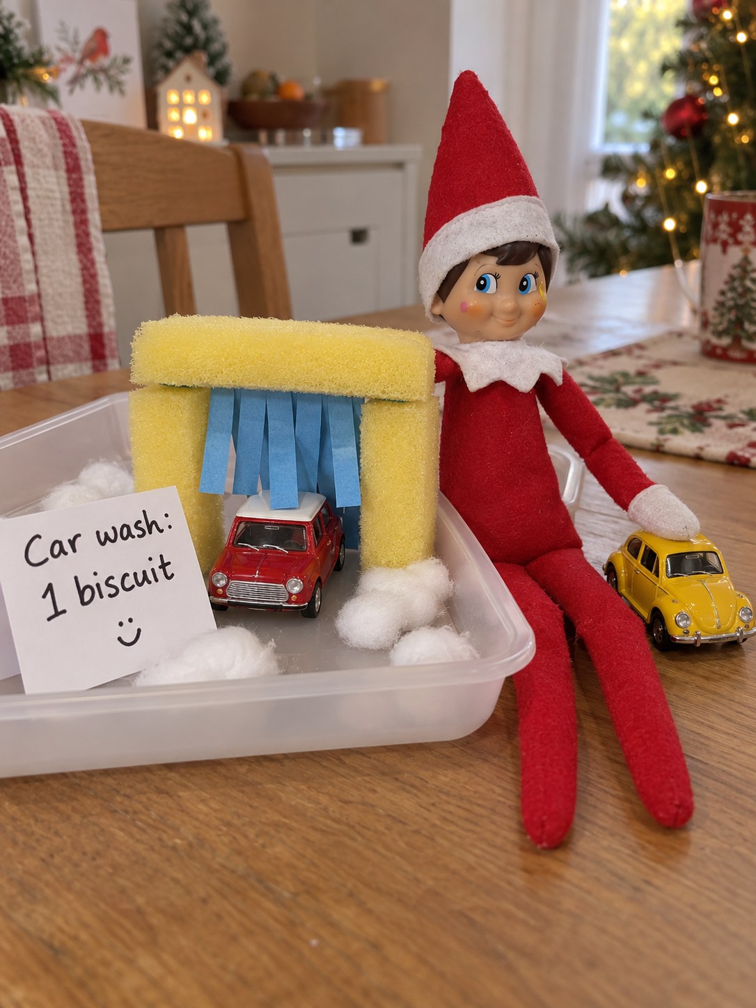 Tom’s elf beside a sponge and paper toy car wash with two small cars